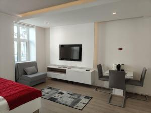 a bedroom with a bed and a tv on a wall at Central Point Privilege Apartments in Sarajevo