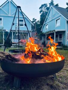 a fire pit in front of a house at Błękitna Przystań Pobierowo in Pobierowo
