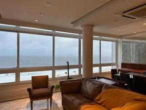 sala de estar con sofá de cuero y piano en Condomínio do Edifício Cannes, en Río de Janeiro