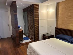 un dormitorio con una cama y un espejo en Condomínio do Edifício Cannes, en Río de Janeiro