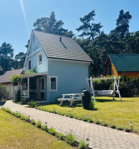 a house with a picnic table in the yard at Błękitna Przystań Pobierowo in Pobierowo