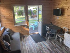 a living room with a couch and a table in a cabin at Błękitna Przystań Pobierowo in Pobierowo +20 photos