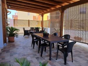 a wooden table and chairs on a patio at Dimora Signore Gallipoli lido in Gallipoli