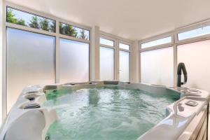 una grande vasca da bagno in una stanza con finestre di Apartament dwuosobowy A07 w Welle a Grzybowo