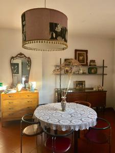 ein Esszimmer mit einem Tisch mit Stühlen und einem Kronleuchter in der Unterkunft Villa Atlantica B&B in Manerbio