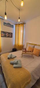 ein Schlafzimmer mit einem großen Bett mit zwei Handtüchern darauf in der Unterkunft Le petit vintage #souvenirs# in Anet