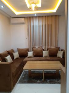 a living room with a couch and a coffee table at Appartement cosy à 8 min de RAK à pied in Marrakesh