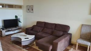 a living room with a couch and a tv at Funchal Apartament Marina View with PARKING FREE in Funchal