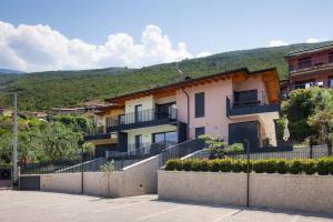a building with a fence in front of a mountain at Modern Apartment with Lake View in Castelletto di Brenzone