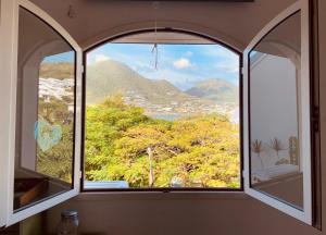 a window with a view of a city and mountains at Villa Serenidad in Cul de Sac