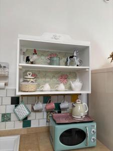 ein weißes Regal mit einer Mikrowelle in der Küche in der Unterkunft Angelica's House in Noto + 49 Fotos