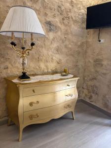 eine Lampe auf einer Kommode neben einer Wand in der Unterkunft Angelica's House in Noto