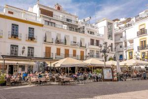 a group of people sitting at tables in front of a building at Casa Sandra in Cómpeta