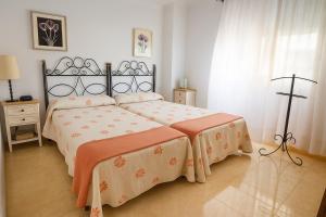 1 dormitorio con 1 cama grande con sábanas de color rosa y naranja en Central Park-Coastal Refuge by the Beach, en Estepona 38 fotos más