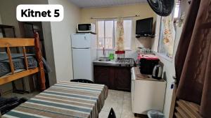 a small kitchen with a refrigerator and a sink at Pousada Triunfo Laranjal in Pelotas