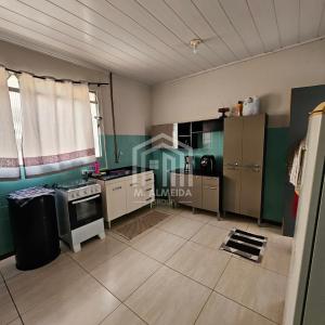 a kitchen with green walls and a stove top oven at Sobreloja - Zona 05 in Maringá
