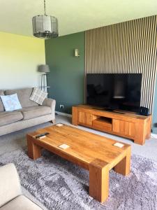 奥克尼Nortaing orkney的配有电视和咖啡桌的客厅
