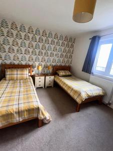 a bedroom with two beds and a window at Nortaing orkney in Orkney +1 photo