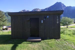 a black shed with a door in the grass at Storviksanden Camping in Storvik +19 photos