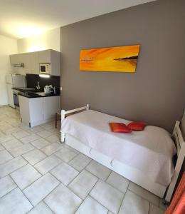 Un dormitorio con una cama y una cocina. en APPARTEMENTS DANS VILLA EN REZ DE JARDIN, en Hyères