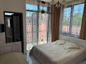 una camera da letto con un letto e una grande finestra di NINO a Kobuleti