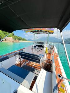 Un barco en el agua con vista a la cabina. en Passeios de Lancha em Ubatuba - New Mar Turismo, en Ubatuba