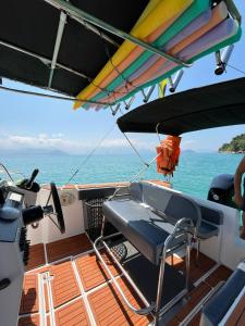 Un barco con una silla y tablas de surf en la cubierta. en Passeios de Lancha em Ubatuba - New Mar Turismo, en Ubatuba