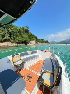 Un barco con dos sillas en la cubierta en el agua. en Passeios de Lancha em Ubatuba - New Mar Turismo, en Ubatuba 6 fotos más