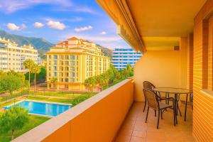 Un balcón con mesa y sillas y una piscina. en Central Park-Coastal Refuge by the Beach, en Estepona
