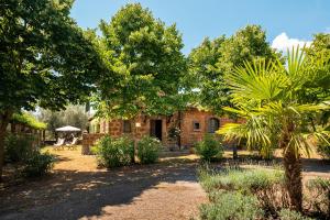 a stone house in the middle of a garden at Casale di Befania in Vetralla