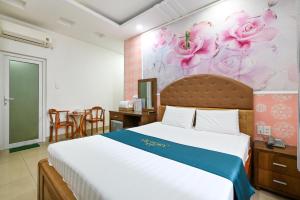 a bedroom with a bed and a wall with flowers at Victory Hotel in Ho Chi Minh City