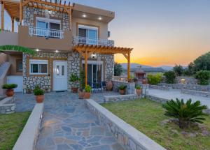 a villa with a view of the sunset at Electi Apartments Charaki in Haraki