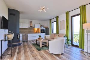Una sala de estar con un sofá blanco y una cocina. en Vineyard house, en Tužno