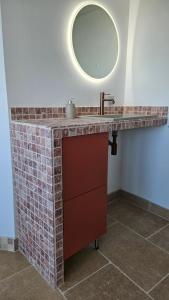 a bathroom with a sink and a mirror at La Tour'angelle in Saint-Étienne-de-Chigny