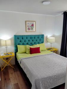 1 dormitorio con 1 cama con cabecero azul y 2 lámparas en Alojamientos Star city, en Santiago