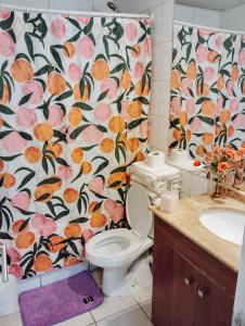 baño con aseo y cortina de ducha con flores en Alojamientos Star city, en Santiago