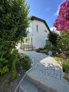 a bench sitting in front of a house with flowers at Apartment Blick Schloss Tarasp - Arventraum mit Gartenspa in Scuol