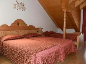 una camera con letto in legno e copriletto rosso di Hotel Milano ad Asiago
