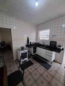 a kitchen with a sink and a counter top at Casa com churrasqueira e piscina in Itanhaém +2 photos