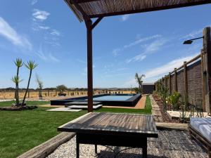 a patio with a wooden bench in a yard at Casa Sítio do Vale, Alandroal in Alandroal