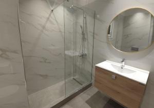 ein Badezimmer mit Dusche, Waschbecken und Spiegel in der Unterkunft K78 Studios B2 in Néa Michanióna