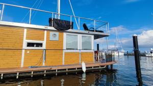 a boat is docked at a dock in the water at ÖKO Budget Hausboot Retreat Mondschein in Stralsund