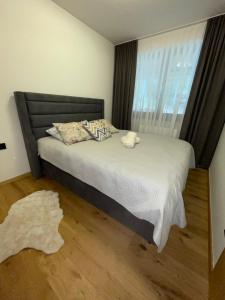 a bedroom with a bed with a large window at Apartman Yellow Bjelasnica in Bjelašnica