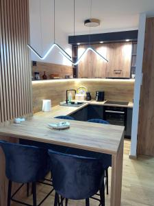 a kitchen with a wooden table and blue chairs at Apartman Yellow Bjelasnica in Bjelašnica +12 photos