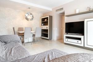 a living room with a television and a dining room at Aqquaria Lujoso in Salou