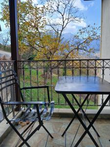 a picnic table and a chair on a balcony at Αρχοντικό in Megalo Chorio