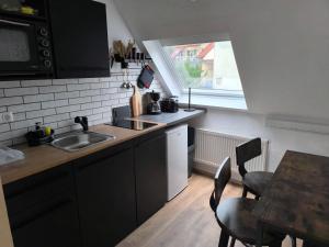a kitchen with a sink and a table with chairs at Alex Meißner App 3 in Großalmerode
