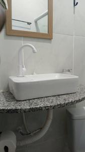 a white sink on a counter in a bathroom at Casinha de Sapê in Santo Amaro