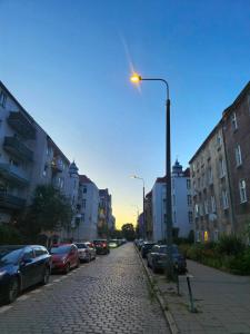 een straatlicht in een stadsstraat met geparkeerde auto's bij Between the Old Town and the Beach in Gdańsk +9 foto's