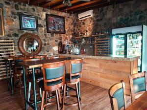 a bar with wooden chairs and a stone wall at Jimmy & Yudy's place in El Triunfo
